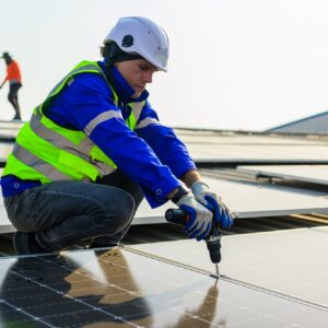 Professional technicians installing solar panels on rooftop of plant